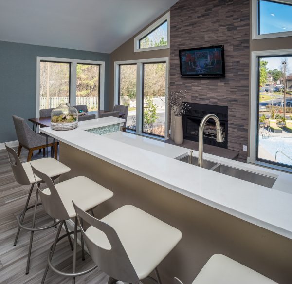 Clubhouse kitchen with ample counterspace, seating and dining options, media, and fireplace