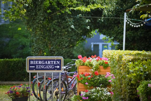 Biergarten entrance sign with beautiful surrounding landscaping and bike rack